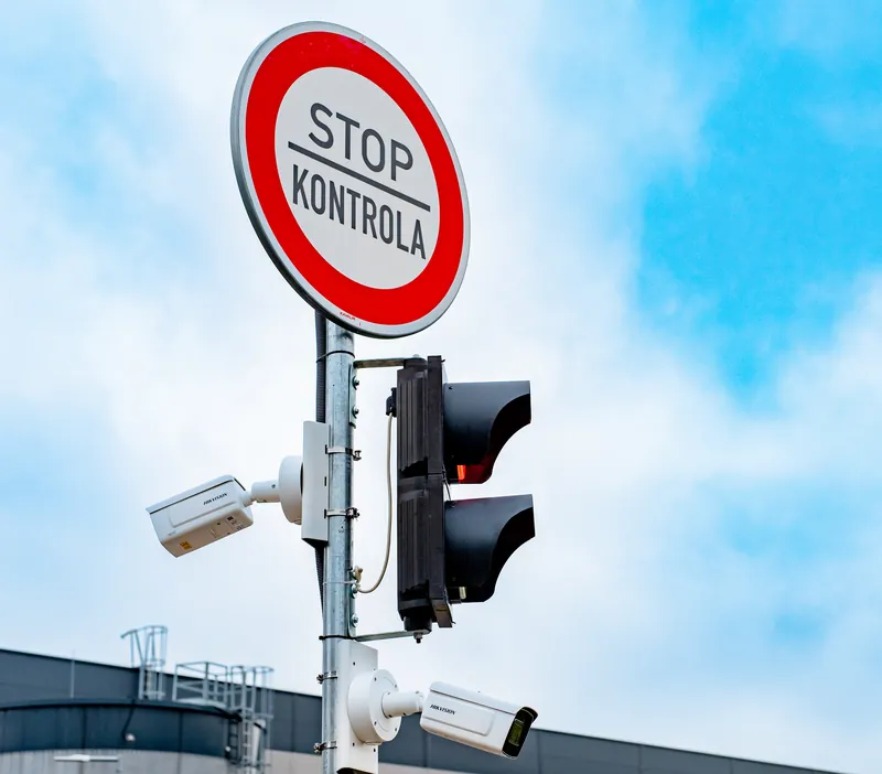 Entry mast at a customer site: STOP CHECK sign, traffic light and two license plate recognition cameras